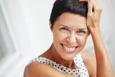 woman smiling after getting her teeth whitened at Centro Dental Las Americas