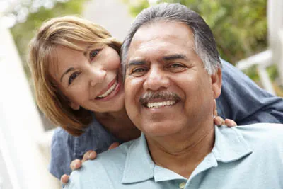 man smiling with his wife after getting dental implants at Centro Dental Las Americas